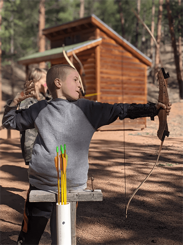 Young boy shooting a bow and arrow
