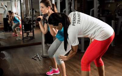 YMCA personal trainer helping a lady workout
