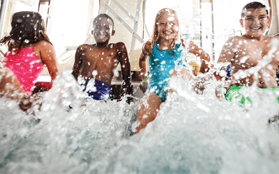 A group of kids splashing water in a pool